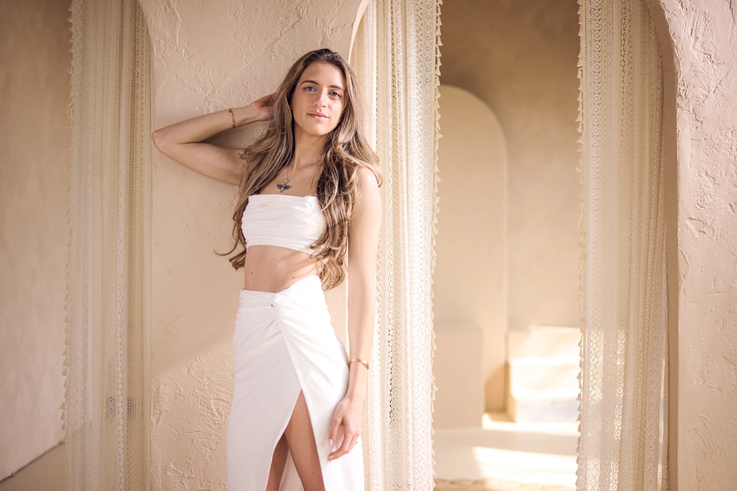 Marissa in white, standing beside the temple’s lace curtains.